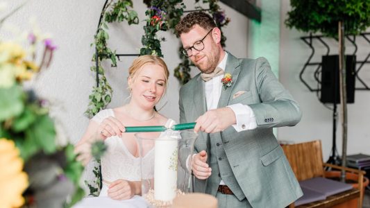 Stimmungsvolle Trauzeremonie auf einem Landgut in Alte Burg bei Jülich. Das Brautpaar entzündet gemeinsam die Hochzeitskerze.
