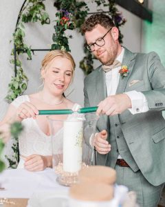 Wenn aus zwei Flammen eine gemeinsame wird - das Brautpaar entzündet die Hochzeitskerze
